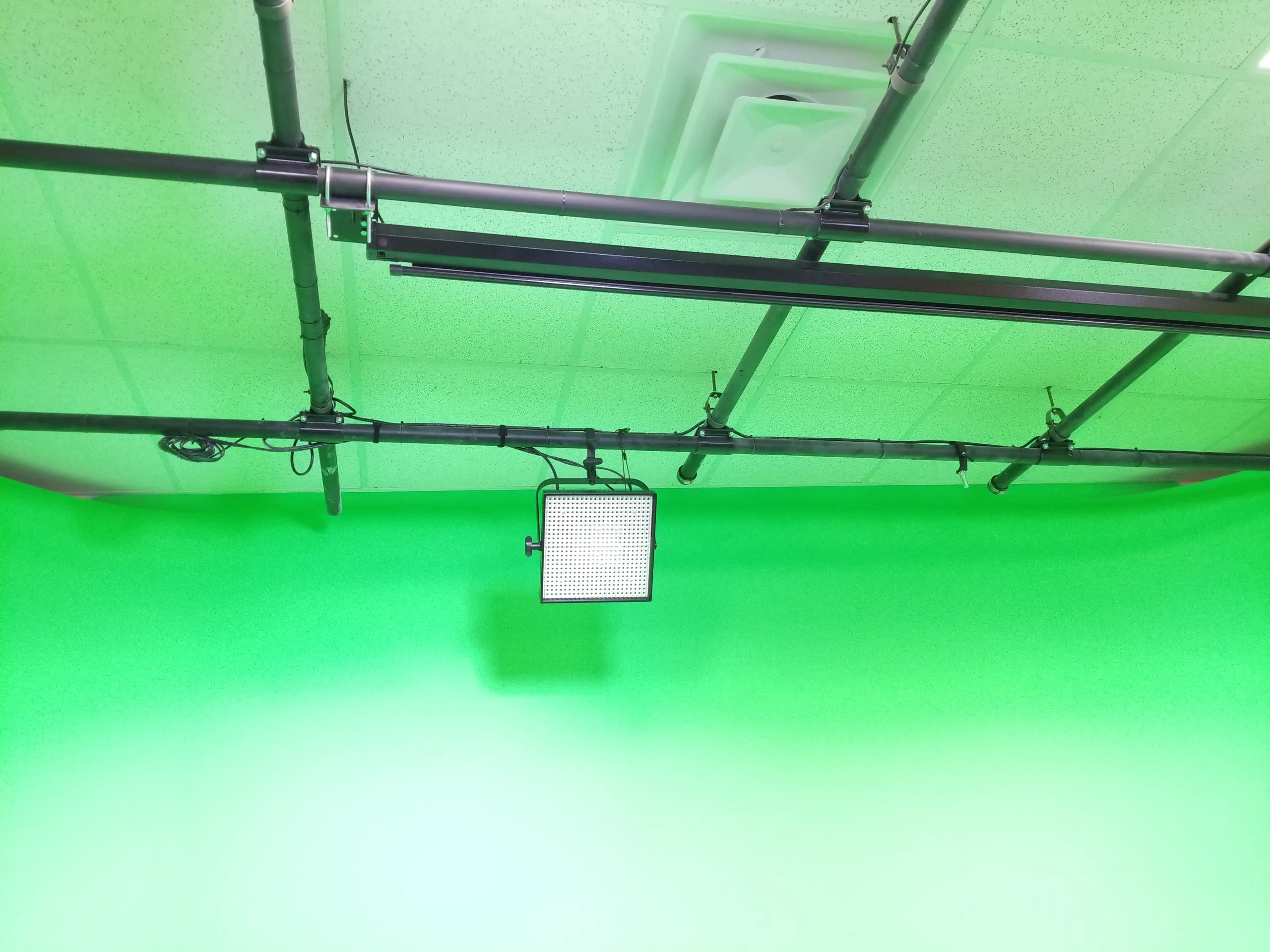 Demo studio floor with green cyclorama and lighting grid