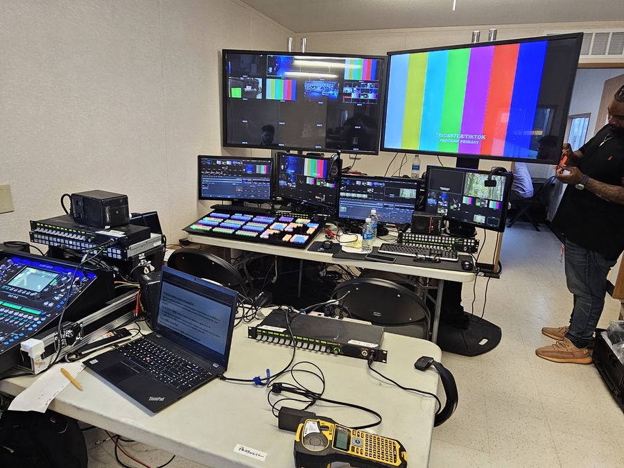 A flypack production system set up on site with monitors showing color bars during a line check.