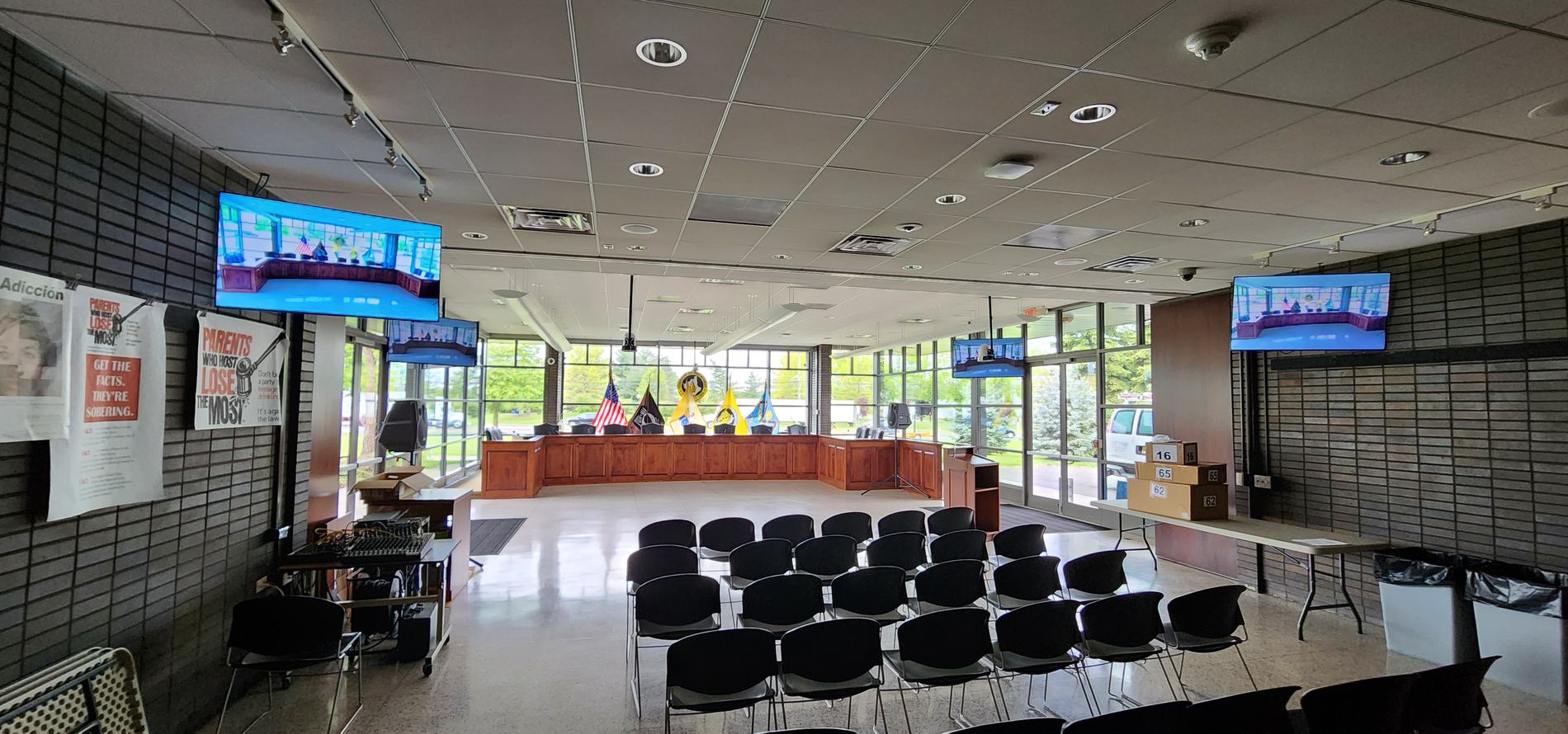 The Piscataway Township council chamber after installation: curved dais, flags, public seating and ceiling displays