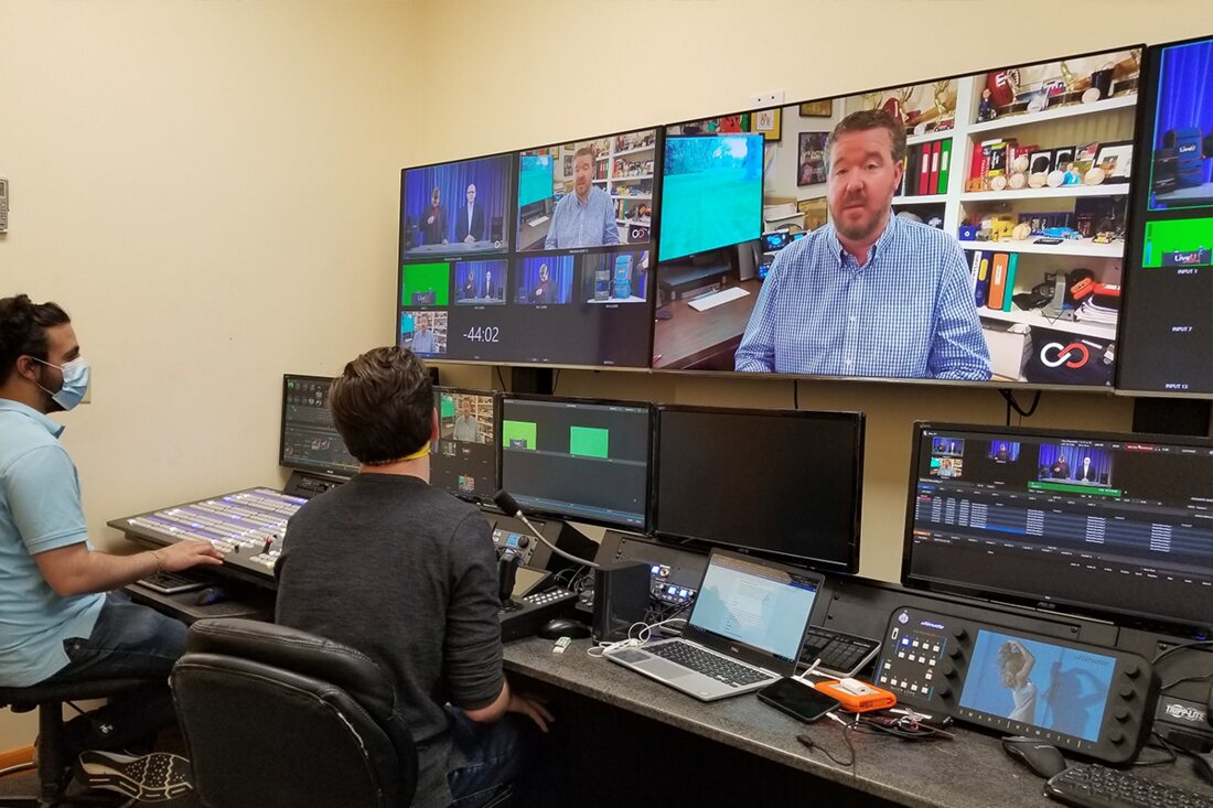 Operators at a multiviewer wall in a control room during a remote production