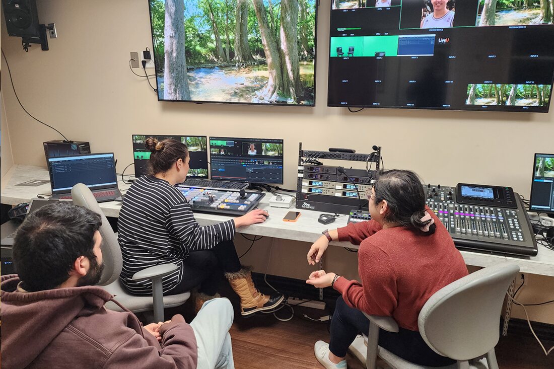 Operators at a multi-destination webcast control position during a live stream