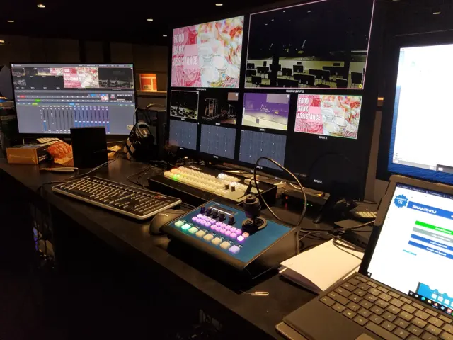 Broadcast control room console with switcher panel and multiviewer wall