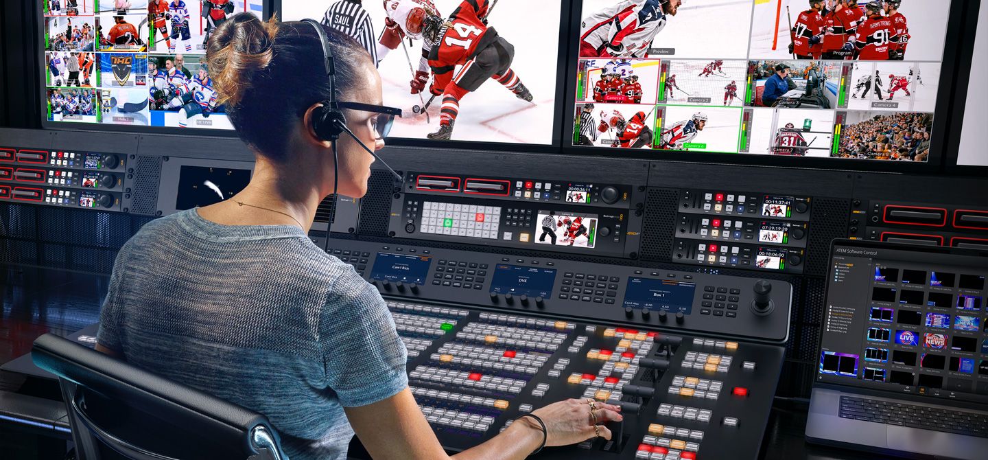 Operator at an ATEM Advanced Panel with a hockey broadcast on the multiview monitors