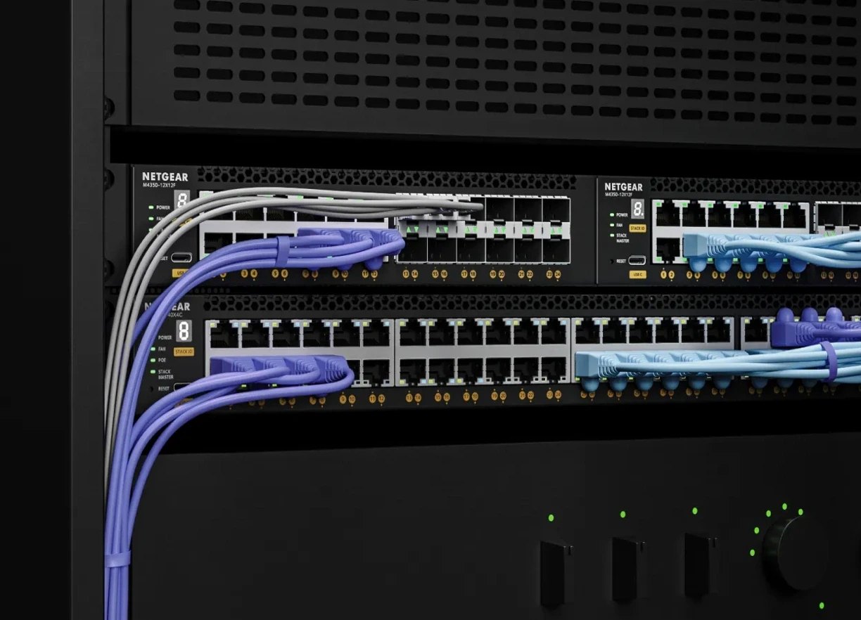 NETGEAR AV switches mounted in an equipment rack with patch cables connected