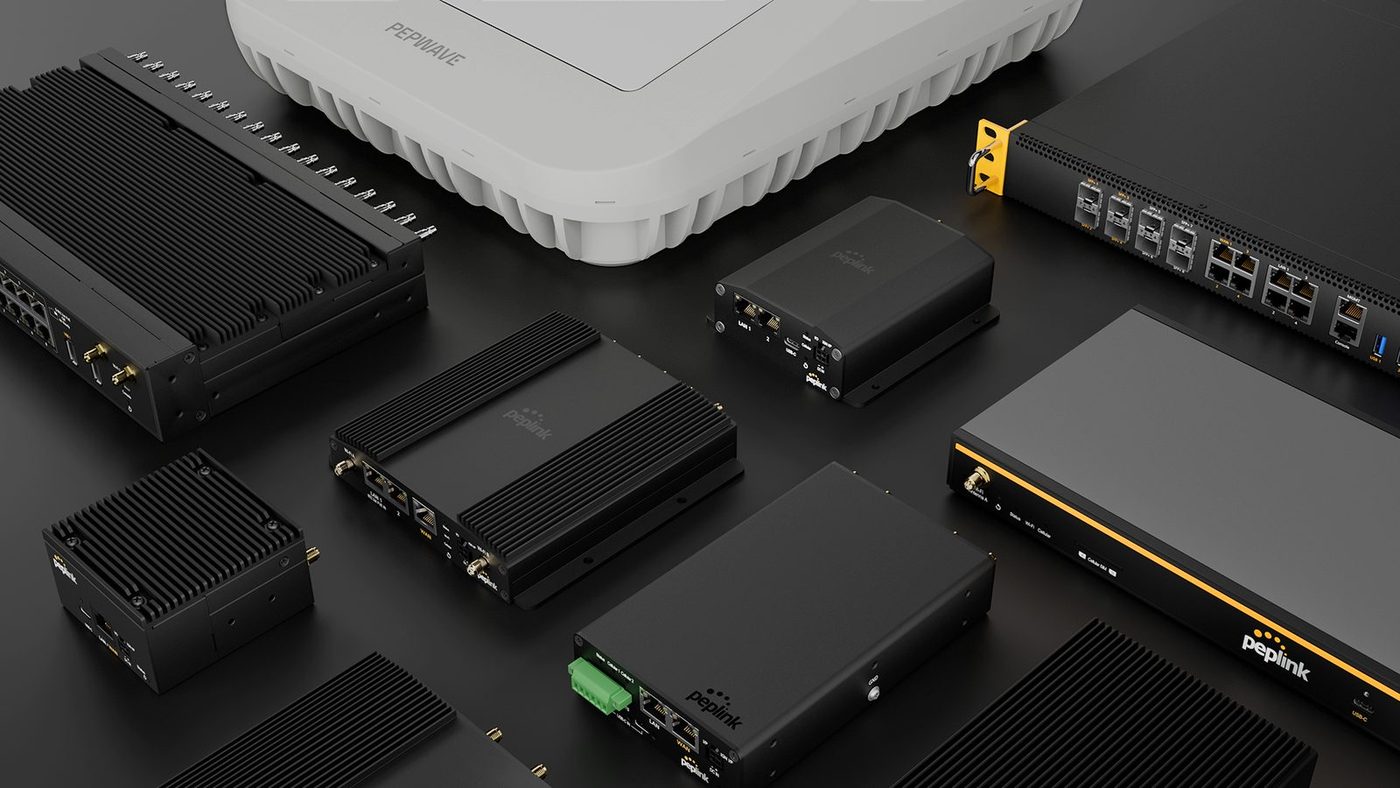 Peplink mobile and branch routers, a rackmount router and a ceiling access point arranged on a dark surface