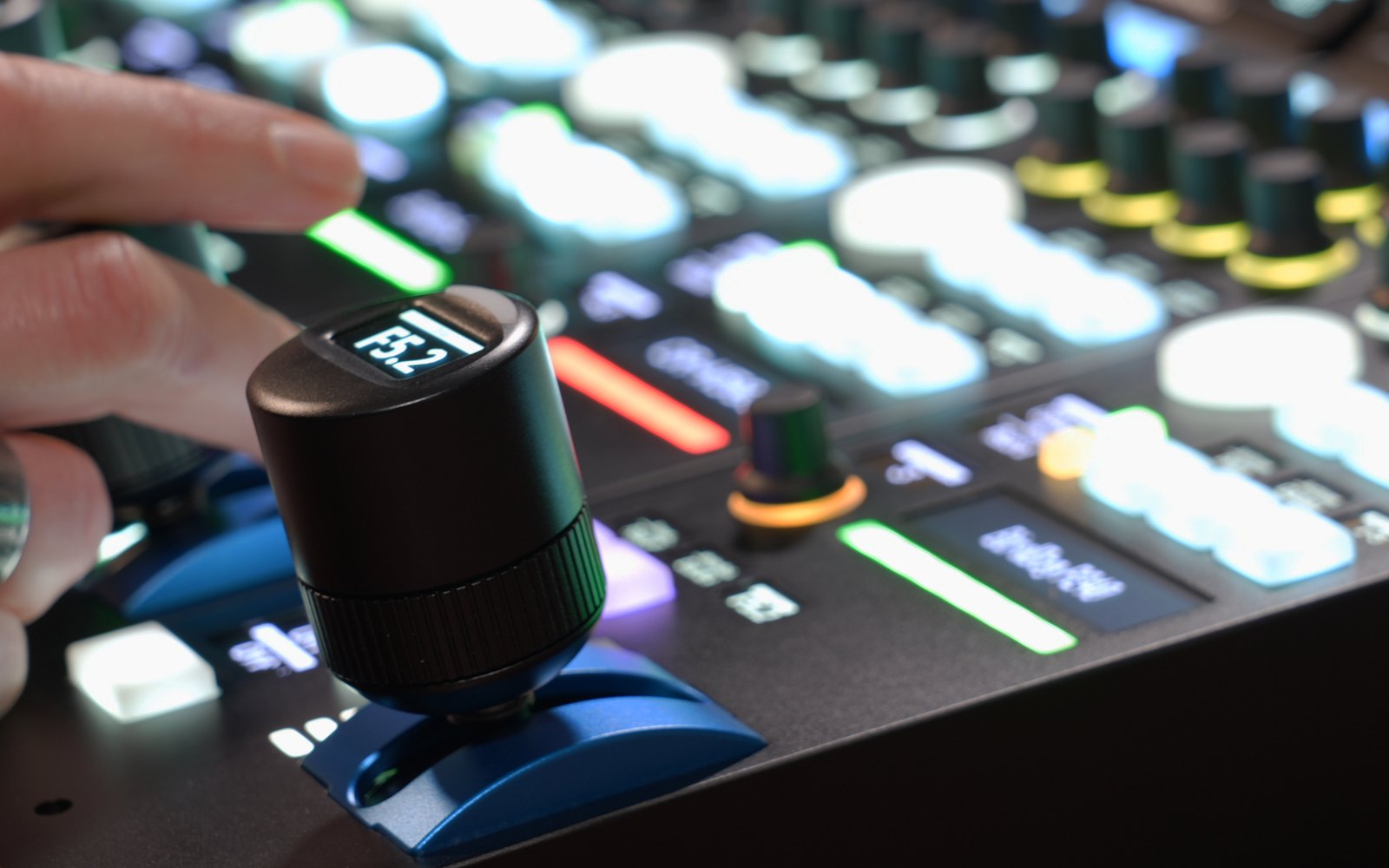 A hand on the joystick of a SKAARHOJ RCP Pro, its display reading F5.2, with lit keys and knobs behind