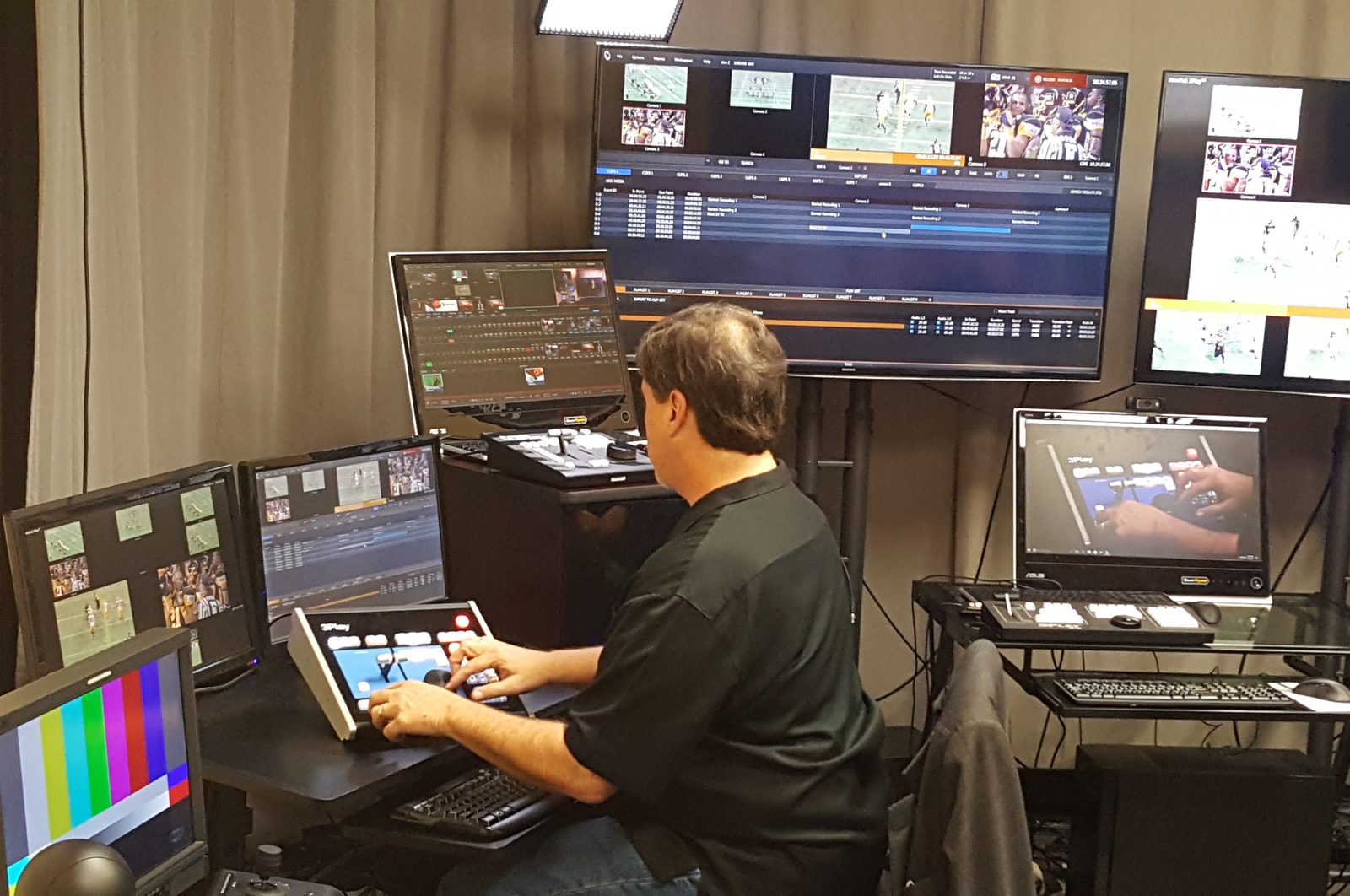 An instructor at a 3Play control surface during operator training, with the replay interface on the monitors