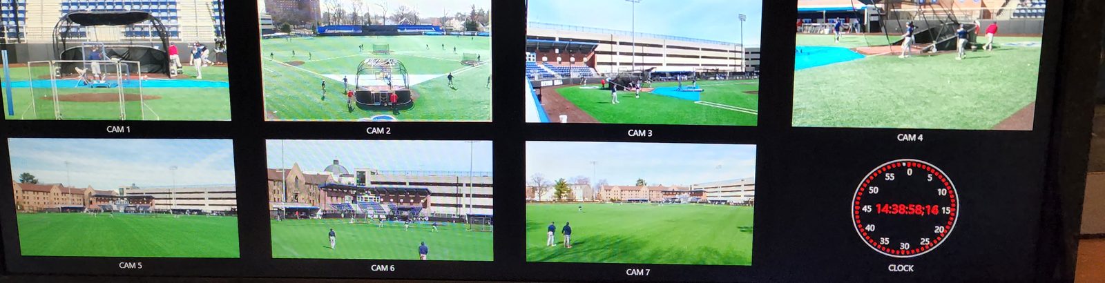 A control-room multiviewer showing seven camera positions around a baseball field and a clock