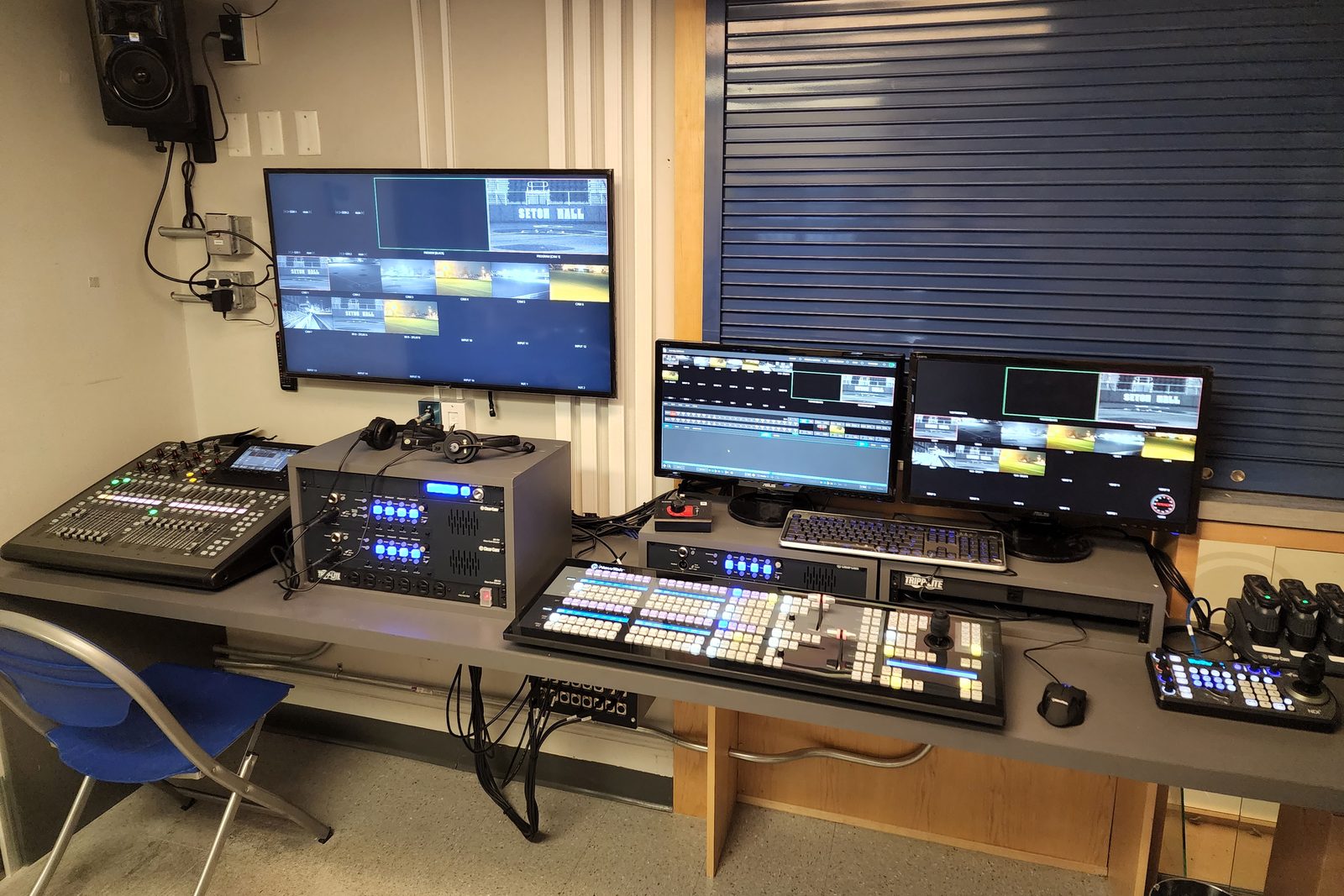 Switching position at Seton Hall University Athletics: TriCaster two-stripe control surface, PTZ joystick controller, audio console, intercom and a wall multiviewer