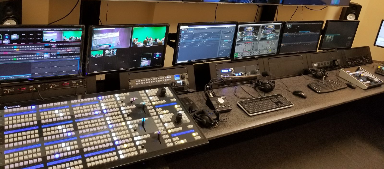 Varto's demonstration control room: a TriCaster four-stripe control surface across a long desk with production monitors