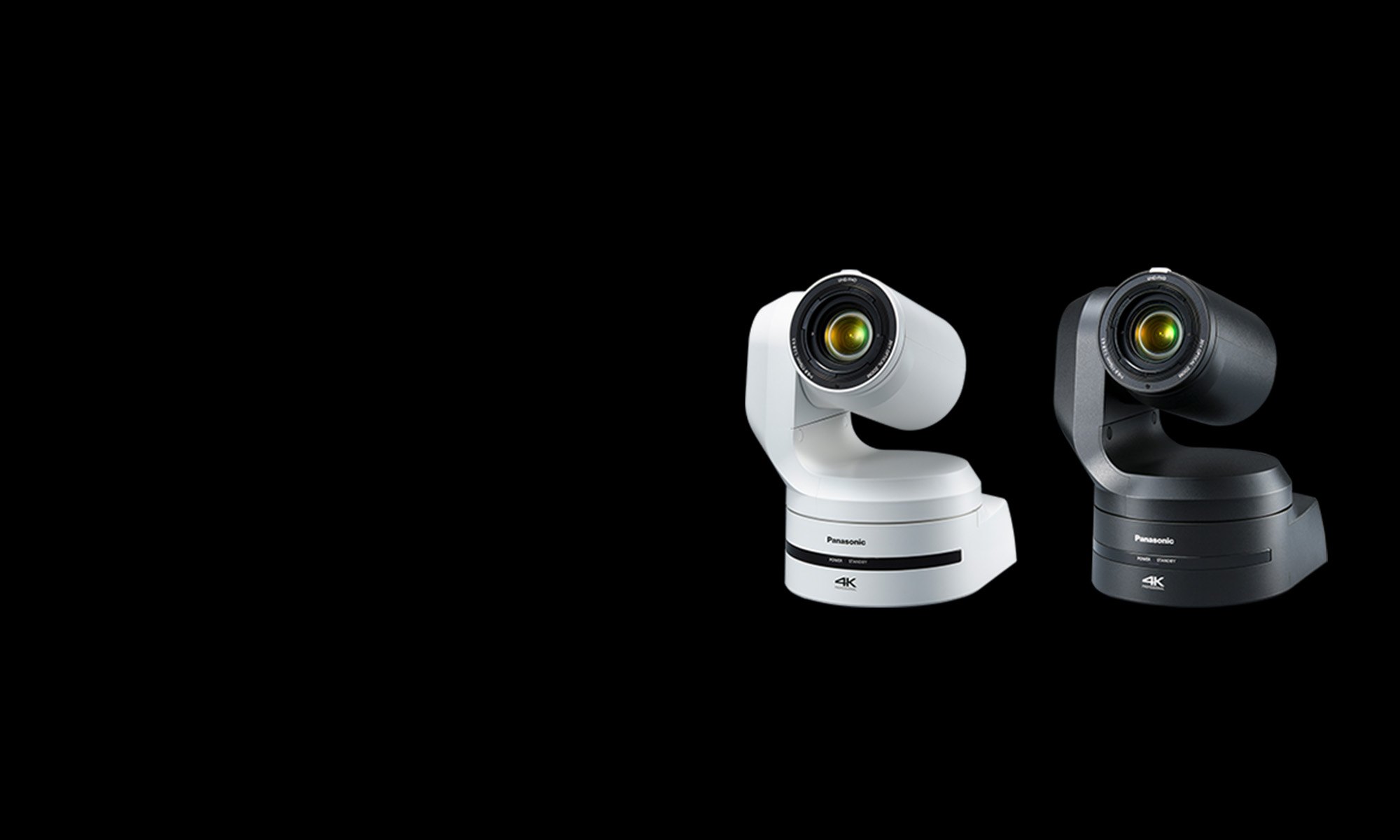 A white and a black Panasonic AW-UE150A PTZ camera side by side on a black background