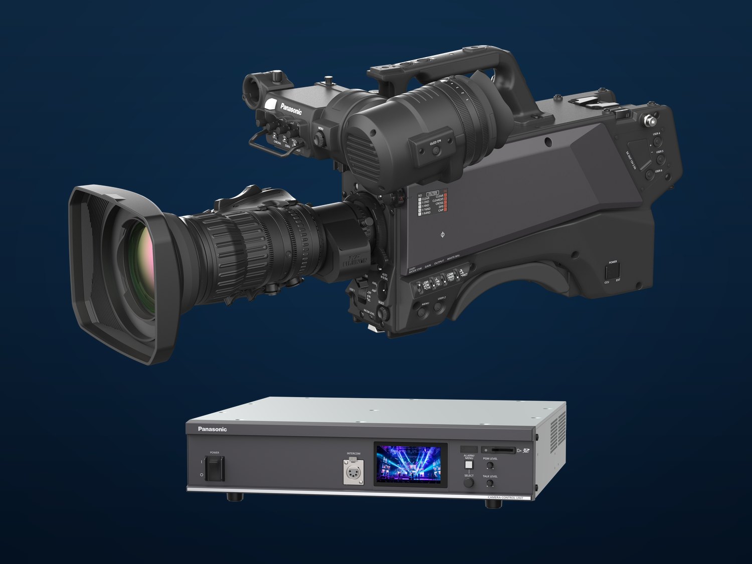 A Panasonic AK-UCX100 studio camera with a box lens and viewfinder above an AK-UCU700 camera control unit, on a dark blue background