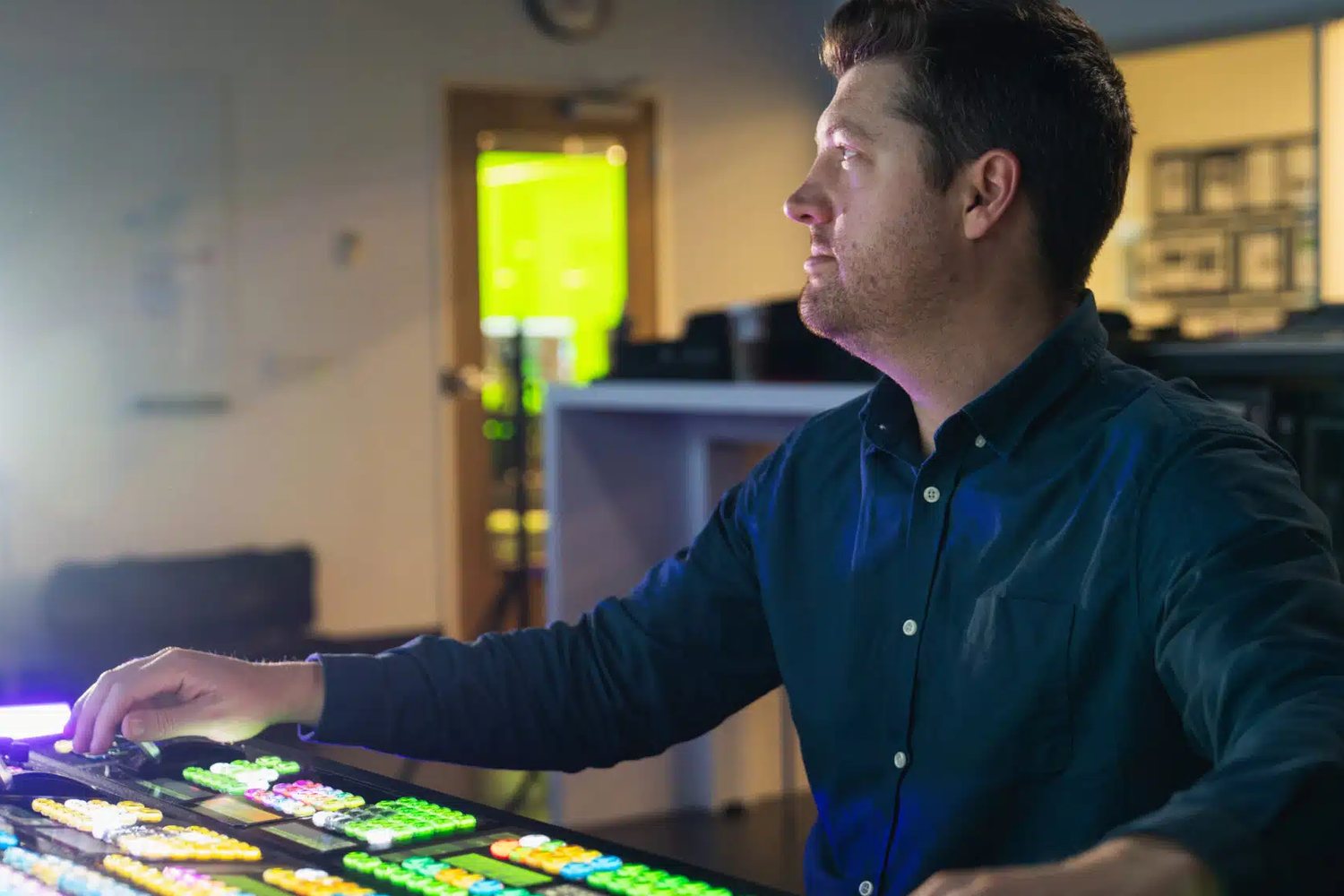 An operator works a backlit TouchDrive switcher panel