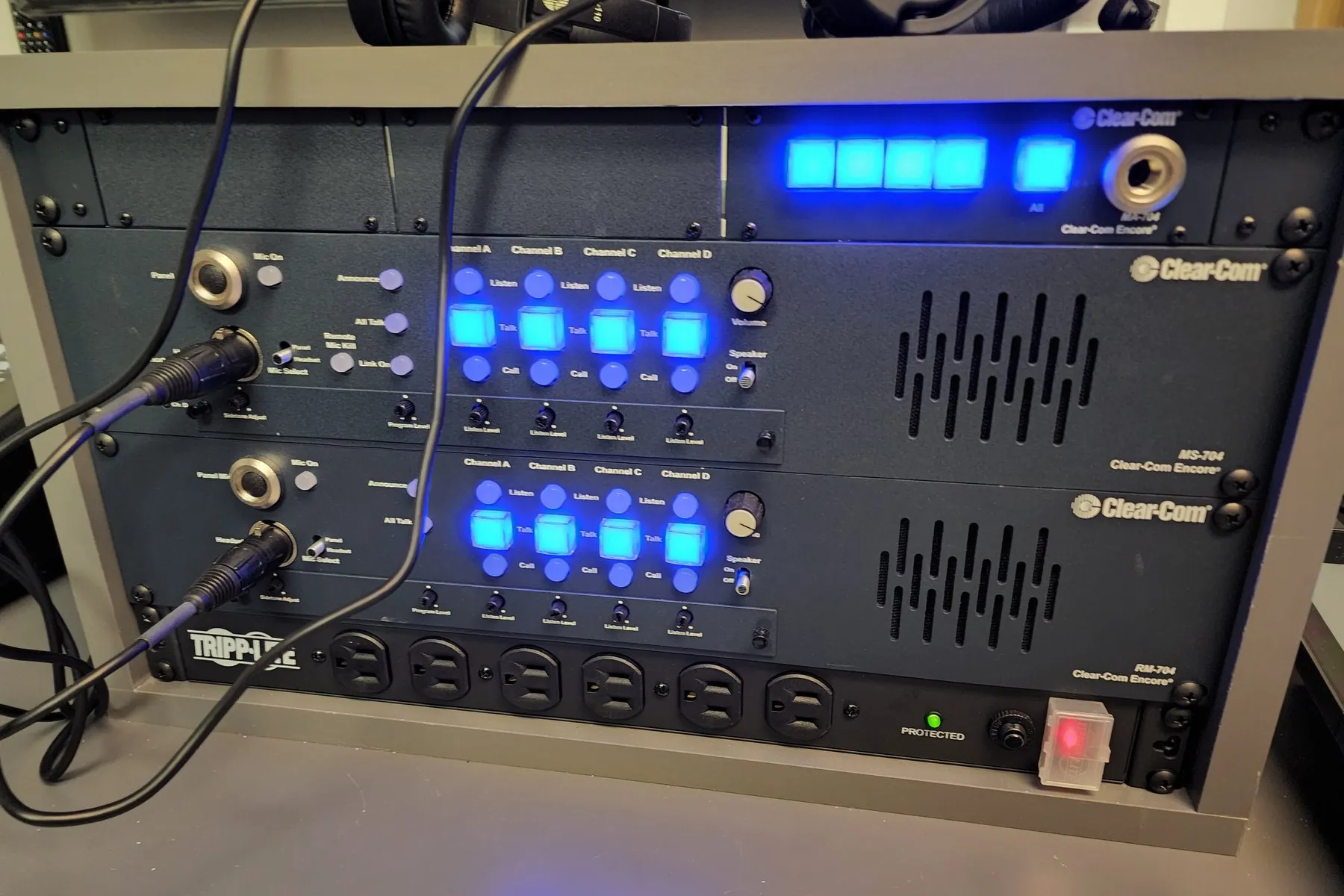 Clear-Com Encore MS-704 and RM-704 four-channel intercom stations in a rack, talk keys lit