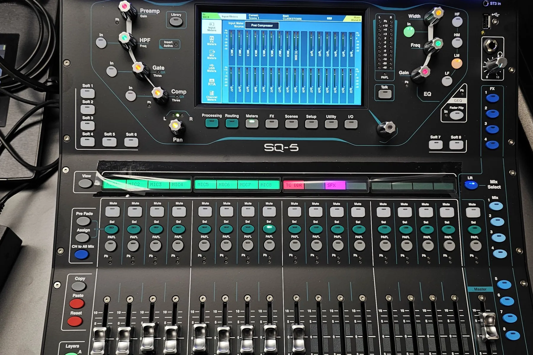 An Allen & Heath SQ-5 digital mixer seen from above, its touchscreen showing the fader bank